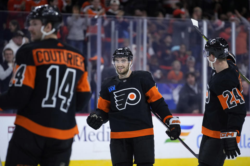 Philadelphia Flyers' Sean Walker, center, celebrates with Nick Seeler, right, and Sean Couturier after scoring a goal during the second period of an NHL hockey game against the Vegas Golden Knights, Saturday, Nov. 18, 2023, in Philadelphia. (AP Photo/Matt Slocum)