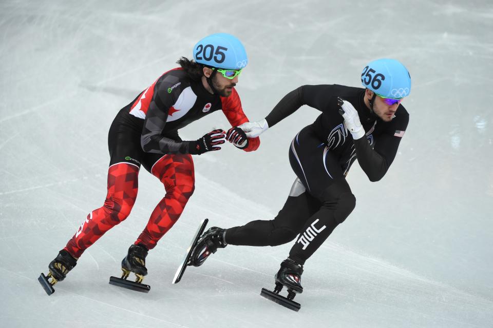 Eduardo Alvarez (USA) (256) and Charles Hamelin (CAN) (205) during the mens short track speed skating 1000m heats during Sochi 2014 Olympic Winter Games at Iceberg Skating Palace on Feb. 13, 2014. 