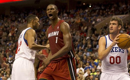 Chris Bosh grita tras encestar mientras Spencer Hawes sostiene el balón durante el partido entre Philadelphia 76ers y Miami Heat, el miércoles 30 de octubre en Filadelfia (EEUU). (Getty Images/AFP | Mitchell Leff)