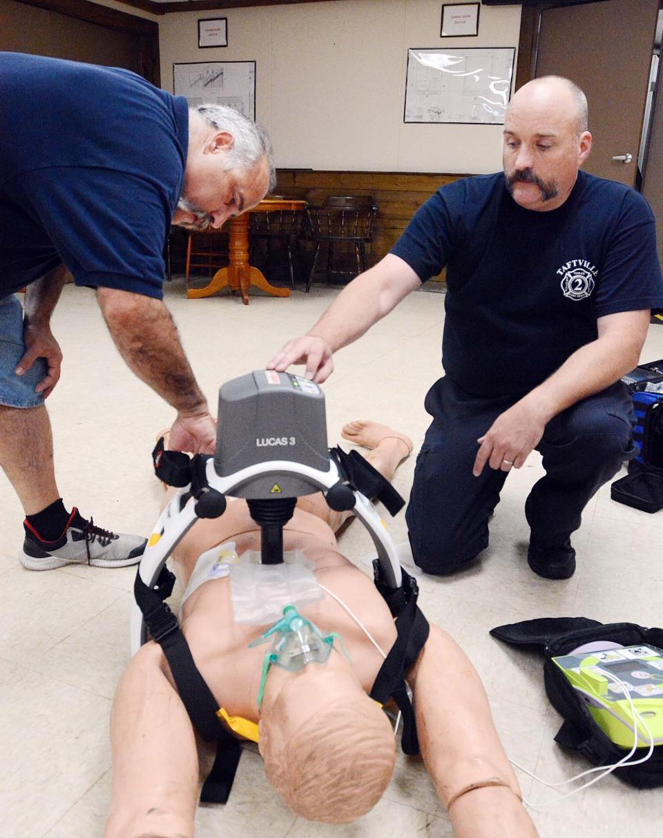 Chief Tim Kencks, left, of Taftville Fire Co. #2, and Assistant Chief Bill Hadam use their automatic CPR device on a dummy in 2019 during a demonstration at the fire station.