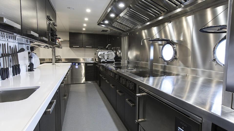 The professional kitchen is much larger than galleys on similar-sized yachts, but the owner wanted to be able to feed 60 at sit-down dinners. - Credit: Courtesy CdM Yachts