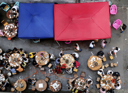 FILE PHOTO: People eat dog meat at a dog meat restaurant district on the day of local dog meat festival in Yulin, Guangxi Autonomous Region, June 22, 2015. REUTERS/Kim Kyung-Hoon/File Photo