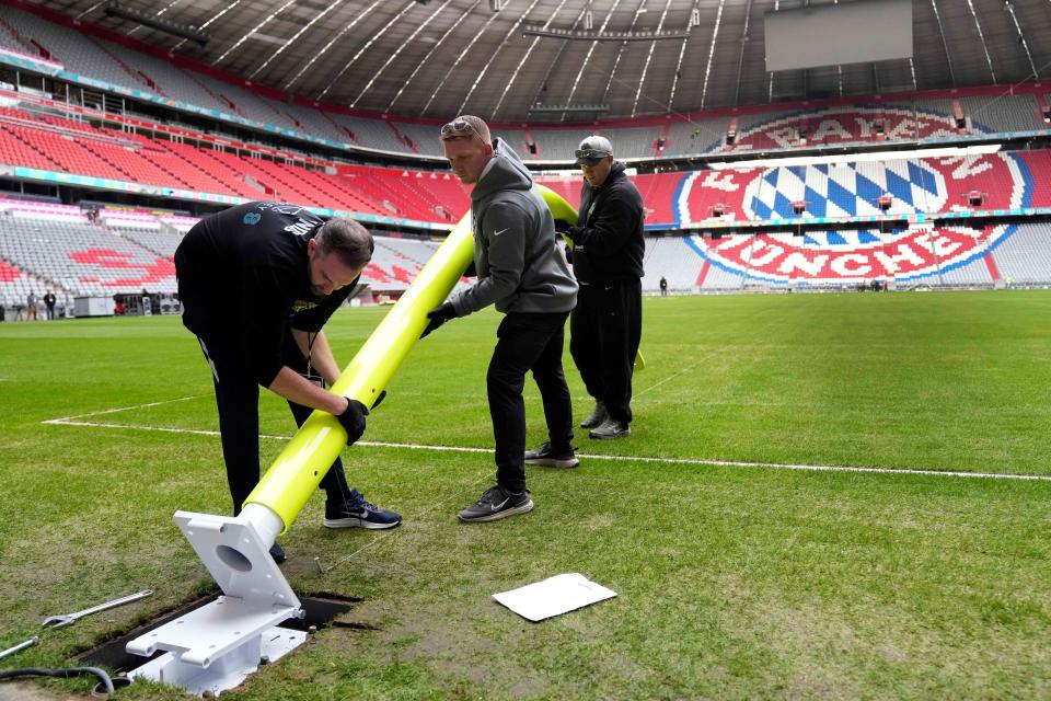 Workers begin installing a goalpost inside Allianz Arena in Munich ahead of Sunday's game between the Buccaneers and Seahawks.