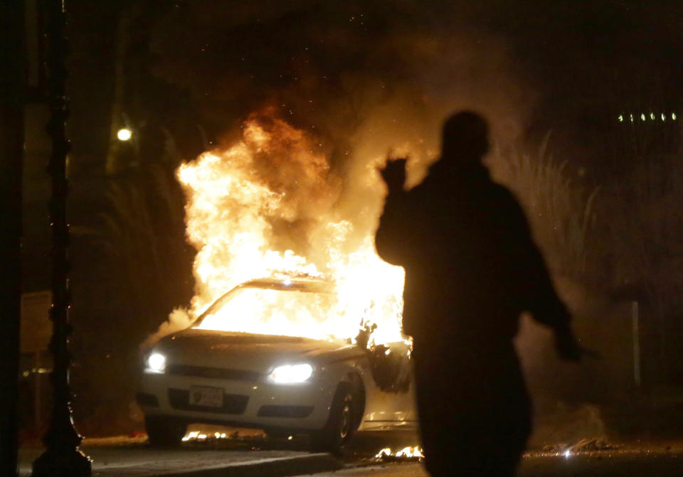 FILE - In this Nov. 24, 2014, file photo, a police car is set on fire amid protests that followed the announcement that a grand jury had declined to indict Ferguson police officer Darren Wilson in the death of Michael Brown. (AP Photo/Charlie Riedel, File)