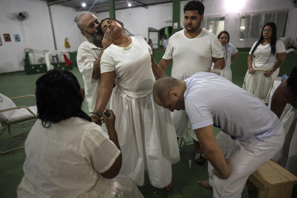 Priest Mauro Oberlaender soothes a devotee at the Umbanda Spiritual Center Caboclo Sete Estrelas, in Rio de Janeiro, Brazil, Saturday, Sept. 3, 2022. Today just a small minority practices Afro Brazilian religions. (AP Photo/Rodrigo Abd)