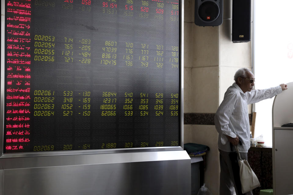 In this Wednesday, Sept. 25, 2019, photo, an elderly Chinese man stands near a display board for stock prices at a brokerage in Beijing. Asian stock markets followed Wall Street higher Thursday, Sept. 26, 2019, after U.S. President Donald Trump suggested a costly tariff war with China could be resolved soon. (AP Photo/Ng Han Guan)