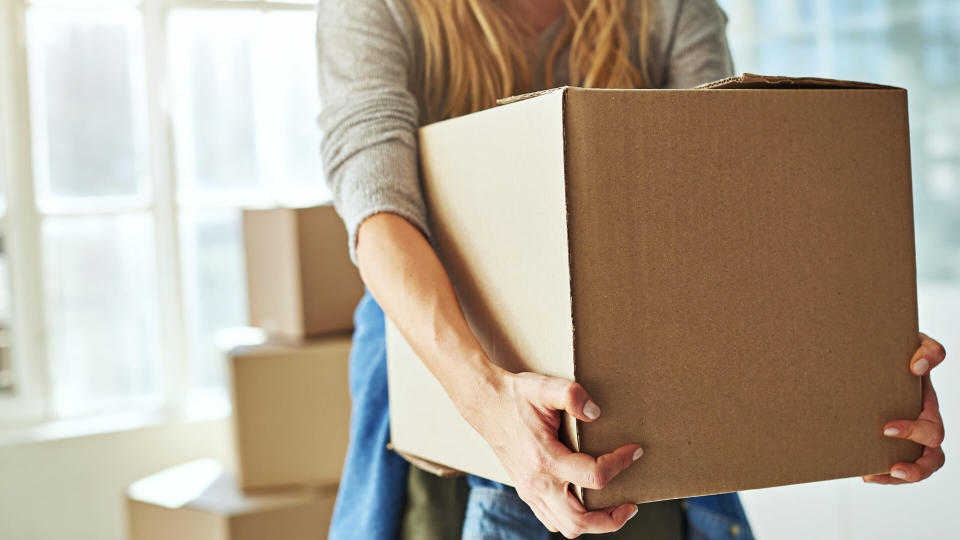 Cropped shot of a young woman carrying boxes while moving into her new home.