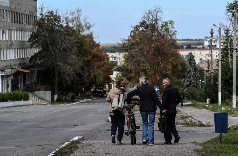 La gente camina por la calle en Balaklia, región de Kharkiv, el 10 de septiembre de 2022, tras la reconquista por parte de las fuerzas ucranianas. (Photo by Juan BARRETO / AFP)