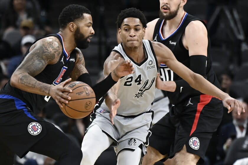 Los Angeles Clippers' Marcus Morris, Sr., left, drives against San Antonio Spurs' Devin Vassell.