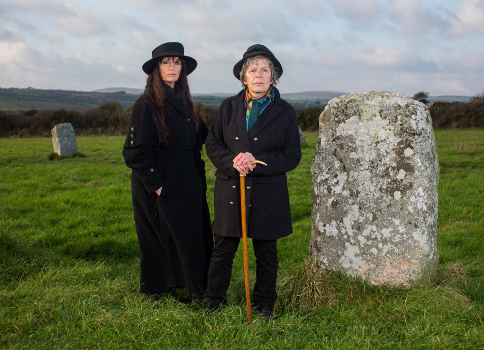 **EMBRAGOED UNTIL 2PM GMT - MARCH 20, 2022**

Cassandra and Laetitia Latham Jones at The Merry Maidens Stone Circle in Cornwall. See SWNS story SWBRwitch.  Meet Britain's first official WITCH who was given unique permission to declare the job on her TAX forms - even claiming spells and potions on expenses.  Cassandra Latham-Jones, 71, was the first person allowed to use the term 'village witch' when she files her returns with the inland revenue.  The self-emplo