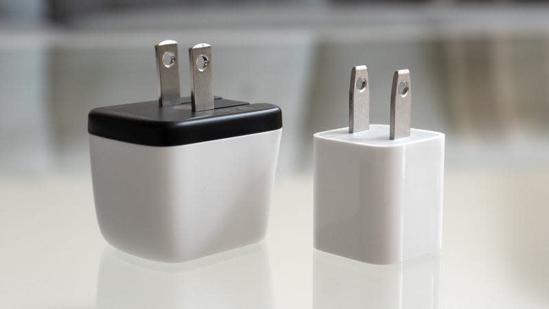 The Human Things Genki Covert Dock Mini sitting next to Apple's 5W iPhone charger.