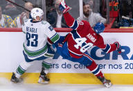 Montreal Canadiens' Joel Armia takes a hit from Vancouver Canucks' Jay Beagle during the second period of an NHL hockey game Tuesday, Feb. 25, 2020, in Montreal. (Paul Chiasson/The Canadian Press via AP)