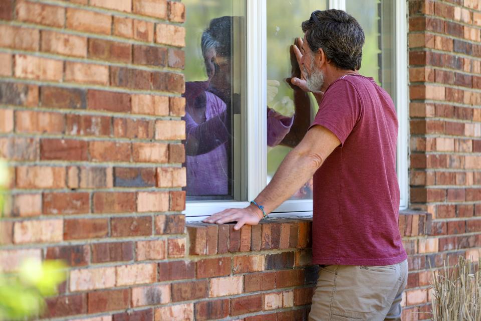 Jack Campise talks with his mother, Beverly Kearns, through her apartment window at the Kimberly Hall North nursing home May 14 in Windsor, Conn.