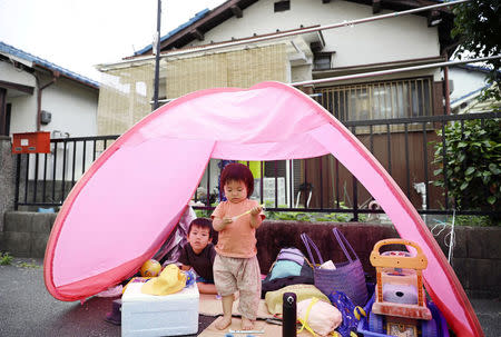 Children evacuate to a temporary tent set up in the garden of their house in Ibaraki, after an earthquake shook Osaka, western Japan, in this photo taken by Kyodo June 18, 2018. Mandatory credit Kyodo/via REUTERS