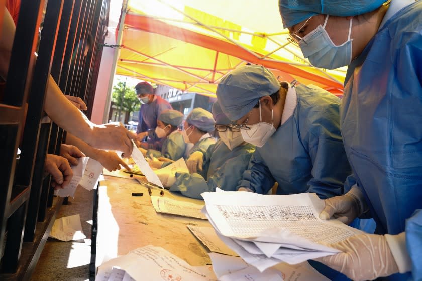 BEIJING, CHINA - JUNE 14: Medical workers wearing protective suits sort nucleic acid test results for the citizens at a hospital on June 14, 2020 in Beijing, China. Beijing has found 43 new coronavirus cases within three days, the number of new infections has risen for the first time for nearly two months. (Photo by Lintao Zhang/Getty Images)