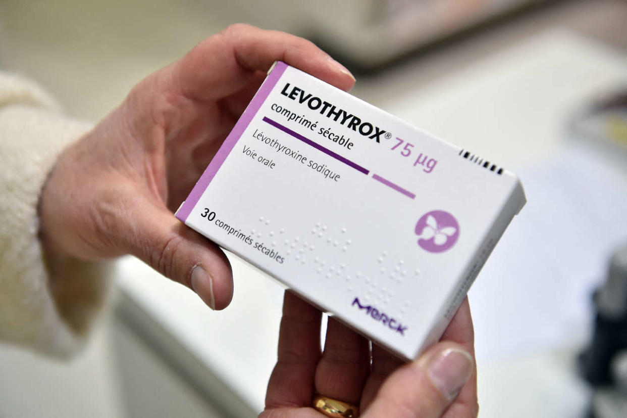 A pharmacist holds a pack of thyroid drug Levothyrox, made by German pharmaceutical company Merck, at a pharmacy in Saint-Gaudens on December 4, 2017. - German pharmaceutical giant Merck, which was ordered by a civil court in Toulouse on November 14 to supply the old version of thyroid drug Levothyrox to 25 plaintiffs, has once again been called before a court, this time in Saint-Gaudens. More than 9,000 people in France have reported serious side effects from a new version of the drug Levothyrox, which Merck is planning to put on the market in other European countries. (Photo by REMY GABALDA / AFP) / RESTRICTED TO EDITORIAL USE