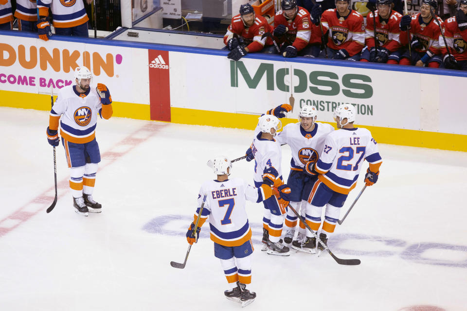 New York Islanders center Mathew Barzal (13), second from right, celebrates his goal with teammates as Florida Panthers players look on from the bench during the third period of an NHL hockey game in Toronto, Friday, Aug. 7, 2020. (Chris Young/The Canadian Press via AP)