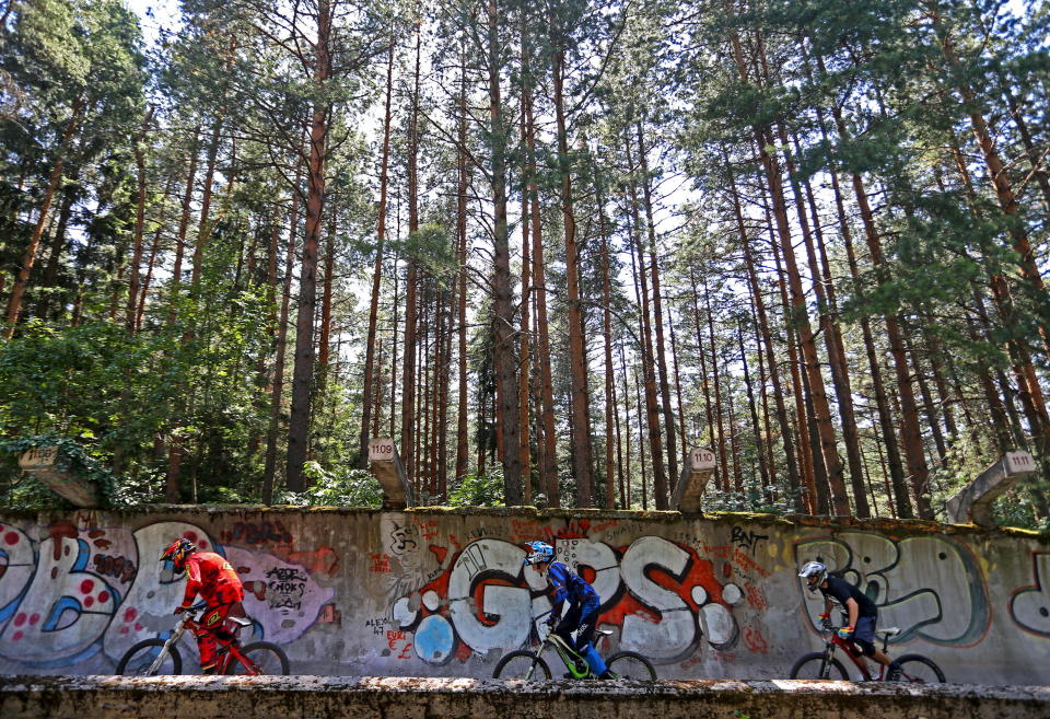 Downhill bikers Kemal Mulic (L-R), Kamer Kolar and Tarik Hadzic train on the disused bobsled track from the 1984 Sarajevo Winter Olympics&nbsp;in&nbsp;2015.