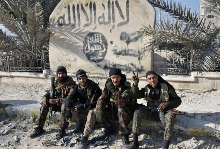 Syrian pro-government forces pictured in front of Islamist graffiti in Aleppo's Bab al-Nairab neighbourhood on December 10, 2016