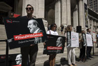 Participants hold signs during a reading event in solidarity of support for author Salman Rushdie outside the New York Public Library, Friday, Aug. 19, 2022, in New York. (AP Photo/Yuki Iwamura)