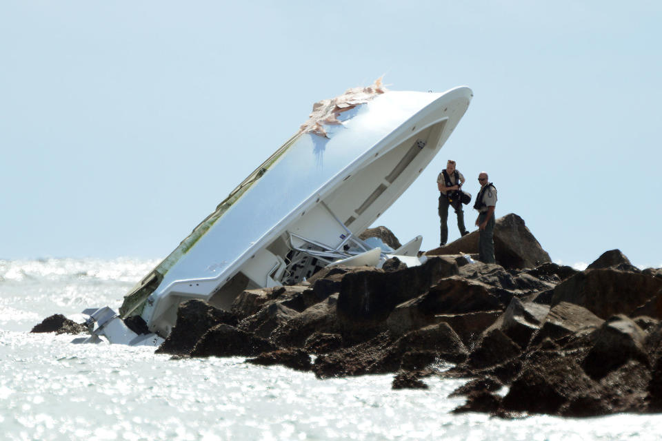 <p>Law enforcement officials inspect a boat overturned on a jetty, Sunday, Sept. 25, 2016, off Miami Beach, Fla. Authorities said that Miami Marlins starting pitcher Jose Fernandez was one of three people killed in the boat crash early Sunday morning. Fernandez was 24. (Joe Cavaretta/South Florida Sun-Sentinel via AP) </p>