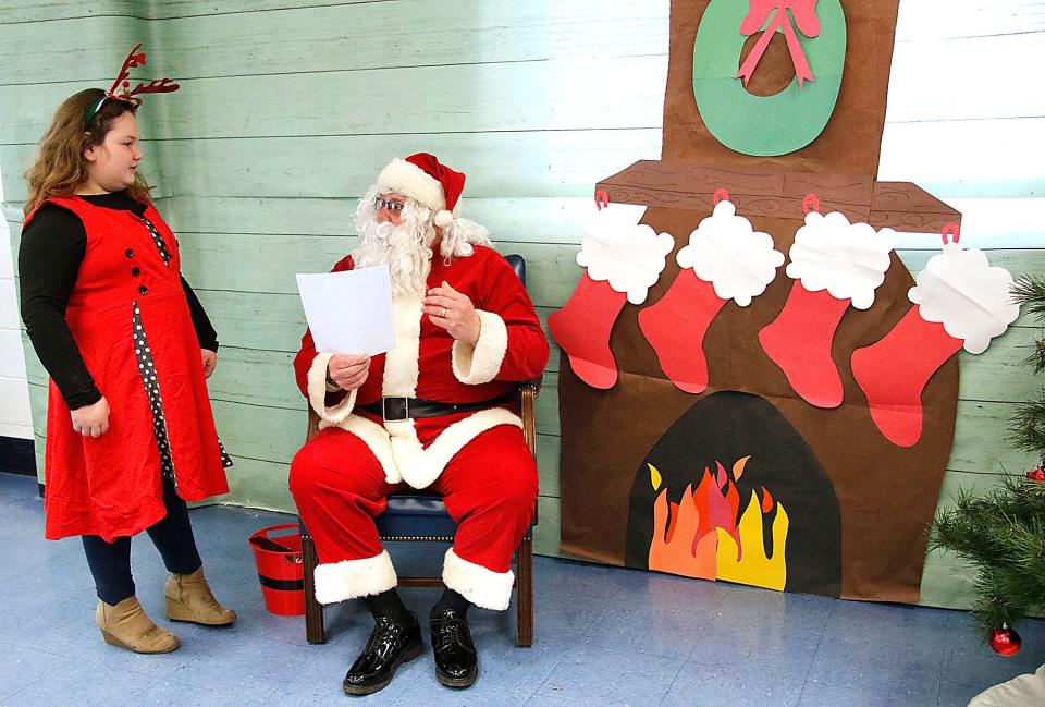 Gabrielle Rinehart talks with Santa after giving him her Christmas wish list at the breakfast with Santa at Mapleton Elementary School on Saturday, Dec. 4, 2021. TOM E. PUSKAR/TIMES-GAZETTE.COM