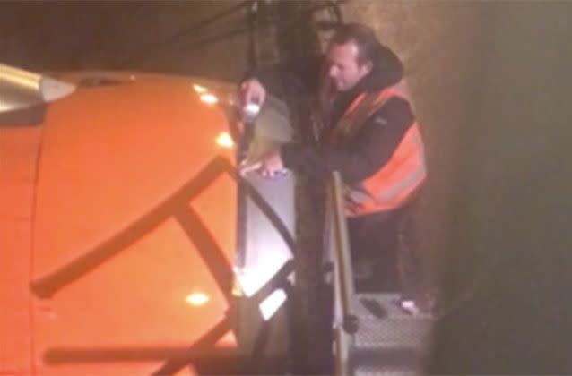 A maintenance man sticks what appears to be duct tape on the engine of an EasyJet plane at Amsterdam's airport. Source: Newsflare