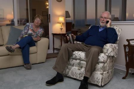 Arthur B. MacDonald, professor Emeritus at Queen's University in Canada, and his wife Janet (L) watch television news shortly after learning that he was a co-winner of the Nobel Prize for Physics at his home in Kingston, Ontario October 6, 2015. REUTERS/Lars Hagberg