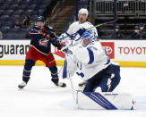 Tampa Bay Lightning goalie Andrei Vasilevskiy, right, stops a shot in front of Columbus Blue Jackets forward Eric Robinson, left, and Lightning defenseman Ryan McDonagh during the second period of an NHL hockey game in Columbus, Ohio, Thursday, April 8, 2021. (AP Photo/Paul Vernon)