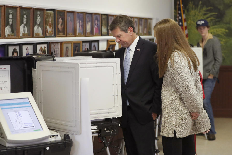 Georgia Republican gubernatorial candidate Brian Kemp casts his ballot as his youngest daughter Amy Porter looks on Tuesday, Nov. 6, 2018, in Winterville, Ga. Kemp is in a close race with Democrat Stacey Abrams. (AP Photo/John Bazemore)