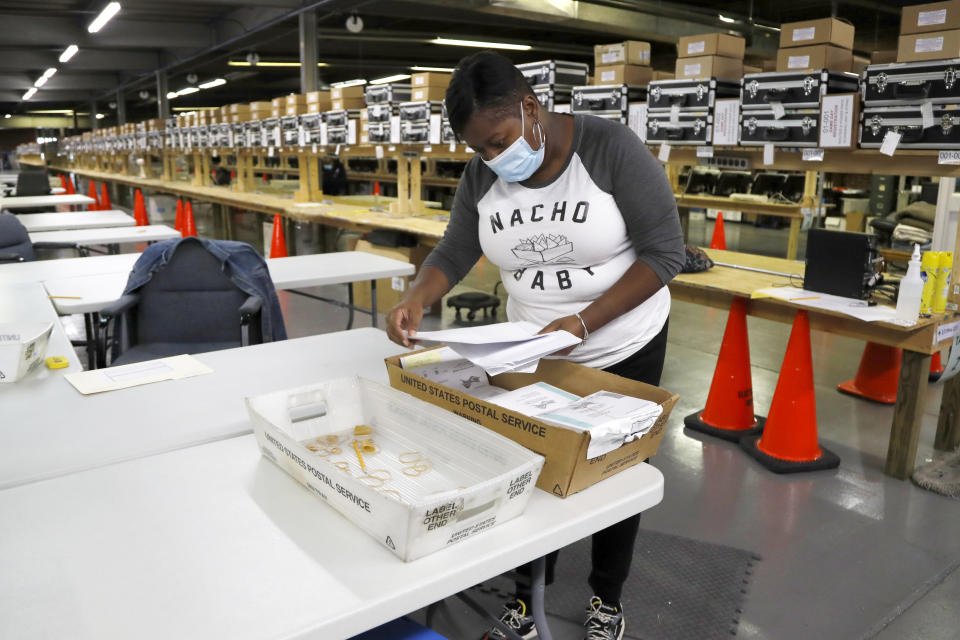 Tamara Debnam, an elections assistant for the Baltimore City Board of Elections, sorts mail-in ballots at a canvasing warehouse ahead of the 7th Congressional District special election, Monday, April 27, 2020, in Baltimore. Democrat Kweisi Mfume and Republican Kimberly Klacik won special primaries for the Maryland congressional seat that was held by the late Elijah Cummings. Voters have been encouraged to mail in their ballots and only three in-person polling centers have been set up across the district in an effort to contain the spread of the new coronavirus. (AP Photo/Julio Cortez)