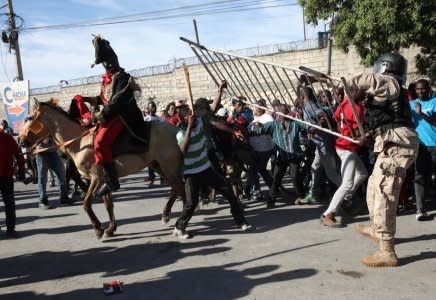 A Haitian National Police officer fights with a protester who grabbed a fence of a police cordon during a protest against reported comments made by U.S. President Donald Trump about Haiti, in the streets of Port-au-Prince, Haiti, January 22, 2018. REUTERS/Andres Martinez Casares