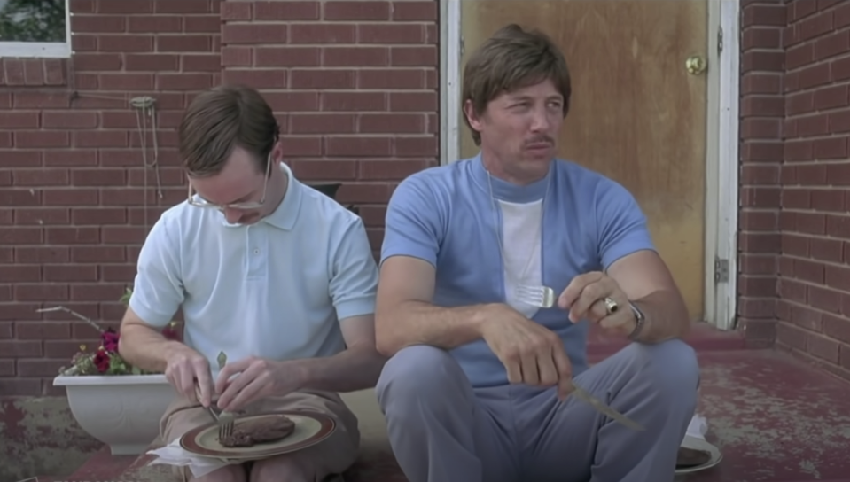 uncle rico sitting outside with someone eating steak