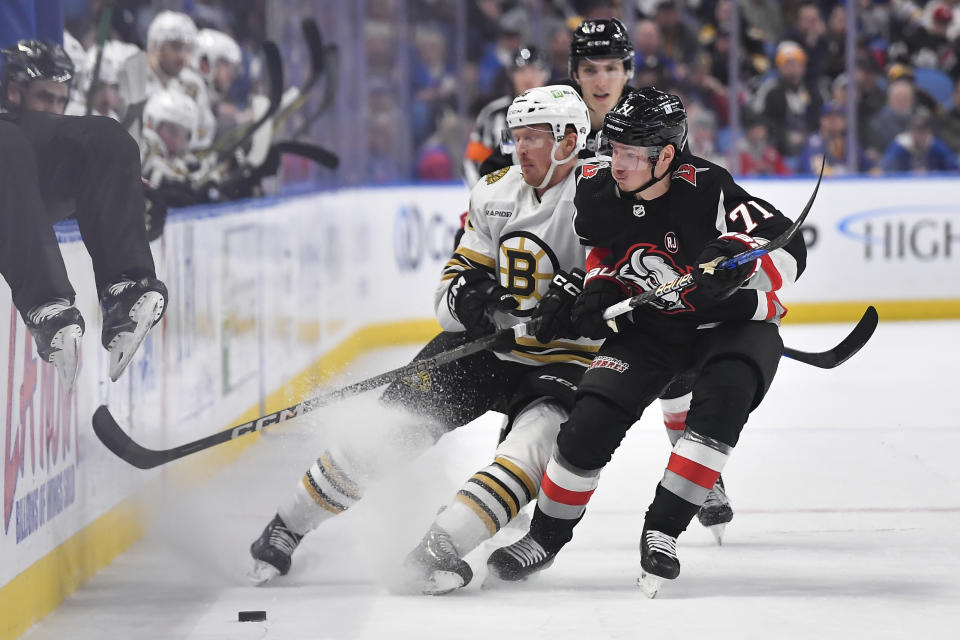 Buffalo Sabres left wing Victor Olofsson, right, checks Boston Bruins center Patrick Brown during the first period of an NHL hockey game in Buffalo, N.Y., Wednesday, Dec. 27, 2023. (AP Photo/Adrian Kraus)