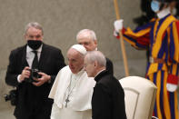 Pope Francis shares a word with Monsignor Luis Maria Rodrigo Ewart as he arrives in the Paul VI Hall at the Vatican for his weekly general audience, Wednesday, Oct. 28, 2020. A Vatican official who is a key member of Francis' COVID-19 response commission, the Rev. Augusto Zampini, acknowledged Tuesday that at age 83 and with part of his lung removed after an illness in his youth, Francis would be at high risk for complications if he were to become infected. Zampini said he hoped Francis would don a mask at least when he greeted people during the general audience. "We are working on that," he said. (AP Photo/Alessandra Tarantino)