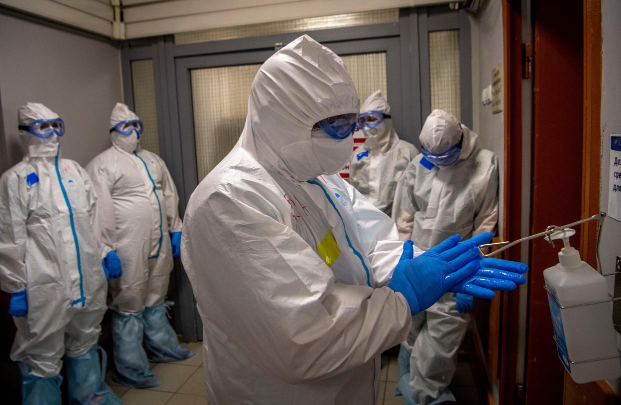 Medical workers wearing protective equipment wait in front of the gateway to enter the red zone to treat coronavirus patients at the Spasokukotsky clinical hospital in Moscow on April 22, 2020. (Photo by Yuri KADOBNOV / AFP) (Photo by YURI KADOBNOV/AFP via Getty Images)