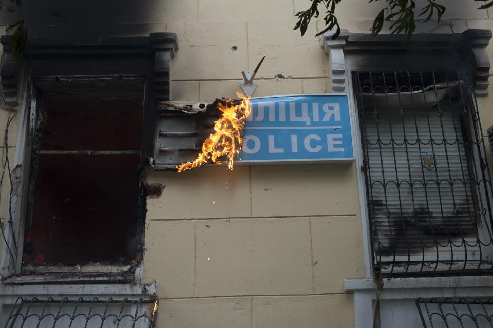 A police station is ablaze in Mariupol in the eastern Ukraine, Friday, May 9, 2014. Fighting between government forces and insurgents in Mariupol has left several people dead. (AP Photo/Evgeniy Maloletka)