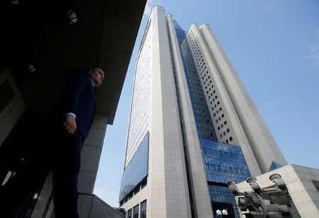 FILE PHOTO: A man walks near the headquarters of Russian gas giant Gazprom during an annual general meeting of the company's shareholders in Moscow, Russia, June 30, 2016. REUTERS/Maxim Shemetov/File Photo