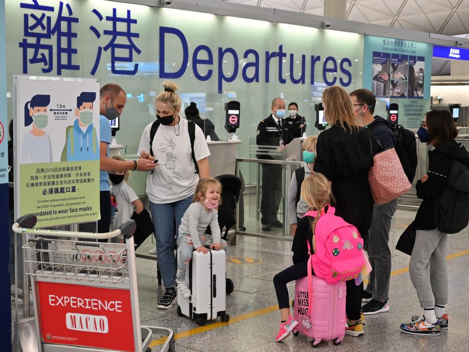 Expat familes line up at the check-in counter as they prepare to depart Hong Kong's Chek Lap Kok international airport on March 6, 2022 as travel restrictions hit hard on Hong Kong's white collar "expat" foreign workers, who make up roughly 10 percent of the population with borders effectively sealed to visitors and residents who do return have faced 2-3 weeks in expensive hotel quarantines throughout most of the pandemic.