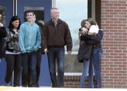 Students of Arapahoe High School hug as others smile while leaving Euclid Middle School, one of the reunification centers, with their families following a shooting incident at Arapahoe High School in Centennial, Colorado December 13, 2013. REUTERS/Mark Leffingwell