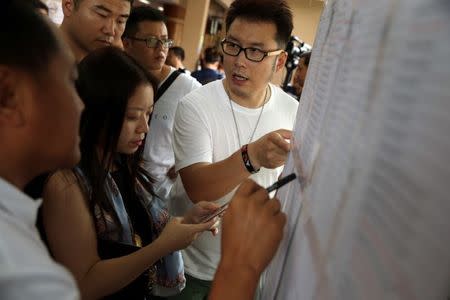 Relatives of Chinese tourists involved in a sunken tourist boat accident, search for their relative's name on a list at a hospital in Phuket, Thailand, July 7, 2018. REUTERS/Athit Perawongmetha