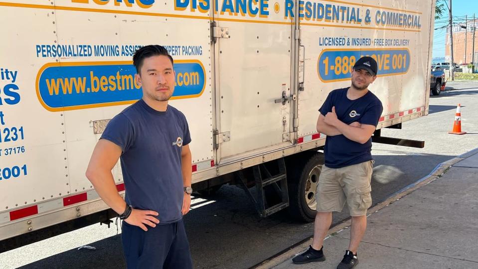 Excellent Quality Movers employees pose by a work truck
