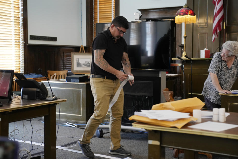 Esmeralda County Commissioner Tim Hipp rolls up printed voting results during a hand recount of votes, Friday, June 24, 2022, in Goldfield, Nev. Commissioners in tiny Esmeralda County on Friday afternoon began hand-counting all ballots after residents raised concerns at their certification meeting on Thursday. (AP Photo/John Locher)