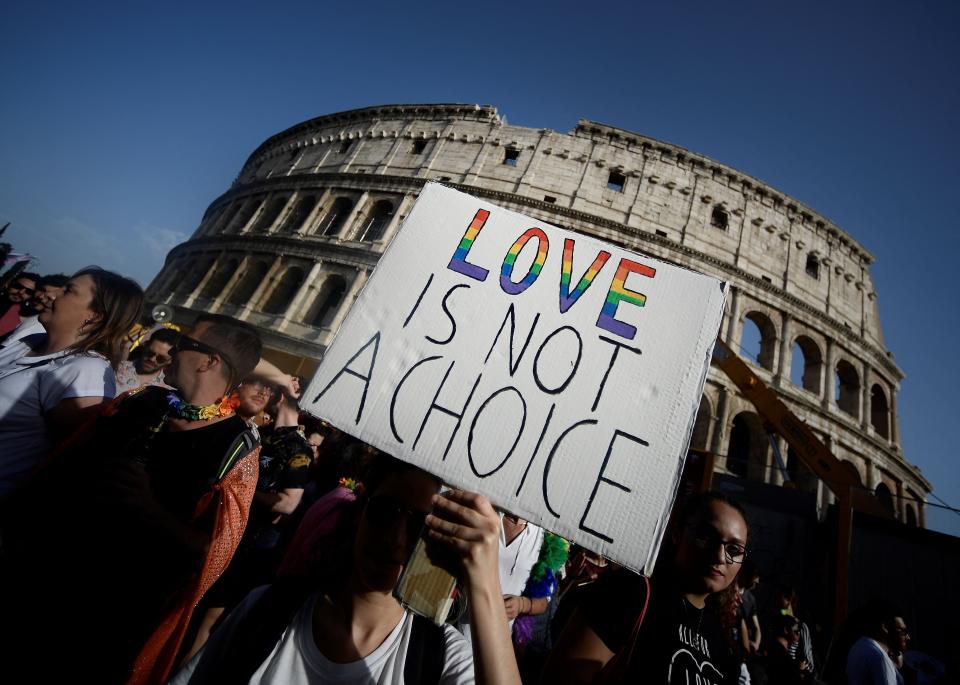 Participants walk past the Colosseum monument in Rome during the annual Gay Pride parade (AFP via Getty Images)