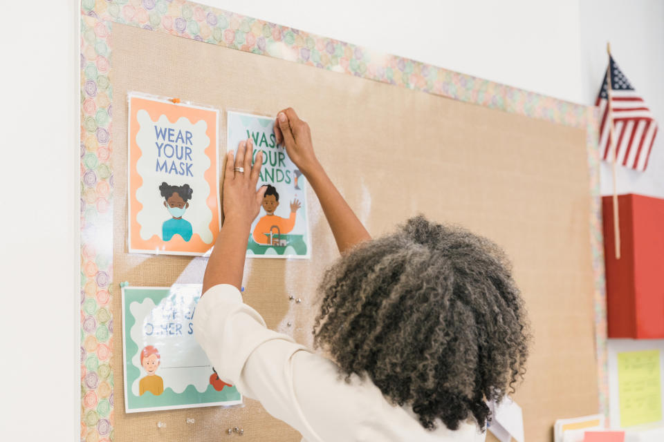 A teacher hanging posters