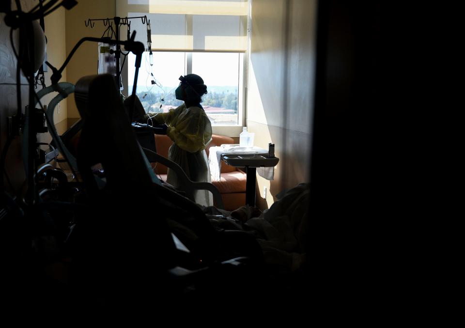 A registered nurse checks on a patient on the COVID floor at Providence Holy Cross Medical Center in Los Angeles on Friday, Feb. 12, 2021.