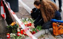 People lay flowers in front of a kebab shop in Halle