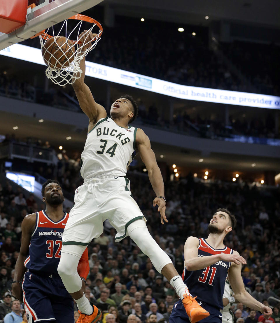 Milwaukee Bucks' Giannis Antetokounmpo (34) dunks against Washington Wizards' Jeff Green (32) and Tomas Satoransky (31) during the second half of an NBA basketball game Wednesday, Feb. 6, 2019, in Milwaukee. (AP Photo/Aaron Gash)