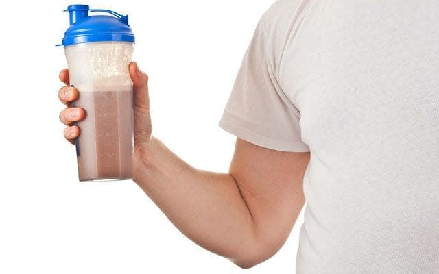 A man holds a post-workout chocolate protein shake - Credit: Deymos Photo / Alamy Stock Photo