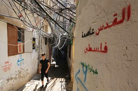 A man walks near electricity cables at Burj al-Barajneh refugee camp in Beirut